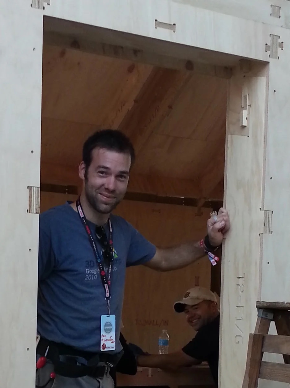 Eric Schimelpfenig standing inside a CNC-fabricated plywood structure he helped build